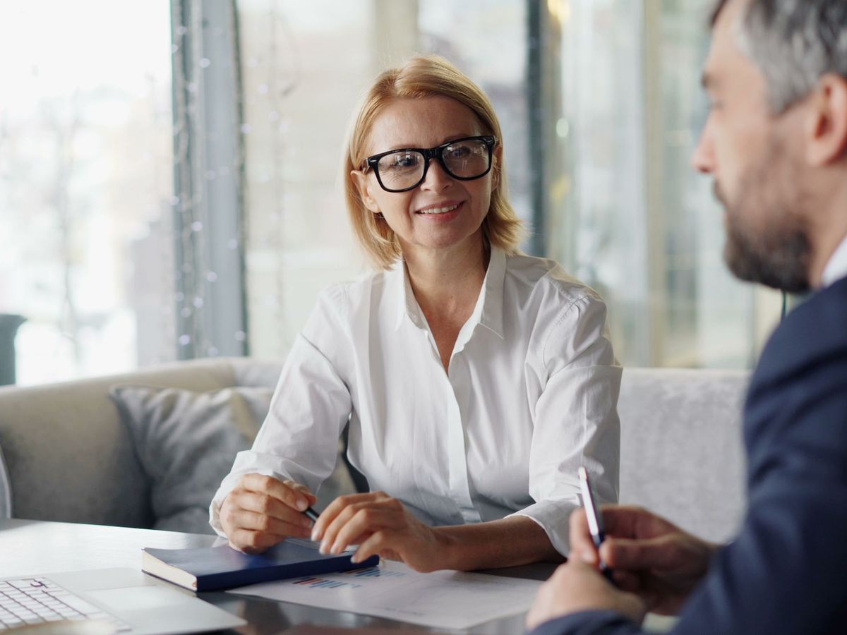 Two people in conversation across a table in an office setting